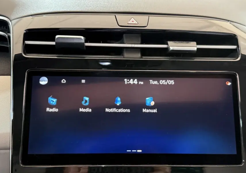 Écran tactile central du tableau de bord du Hyundai Tucson gris foncé, affichant les options radio, media et notifications.