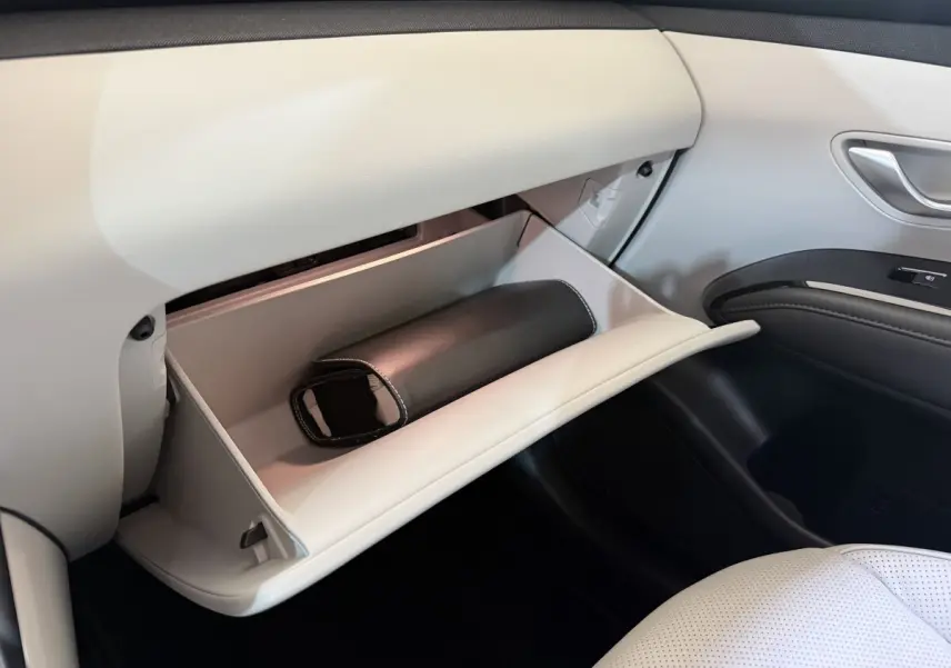 Vue intérieure côté passager du Hyundai Tucson 1.6 Hybrid 230 Executive 2021, boîte à gants ouverte avec pochette noire.