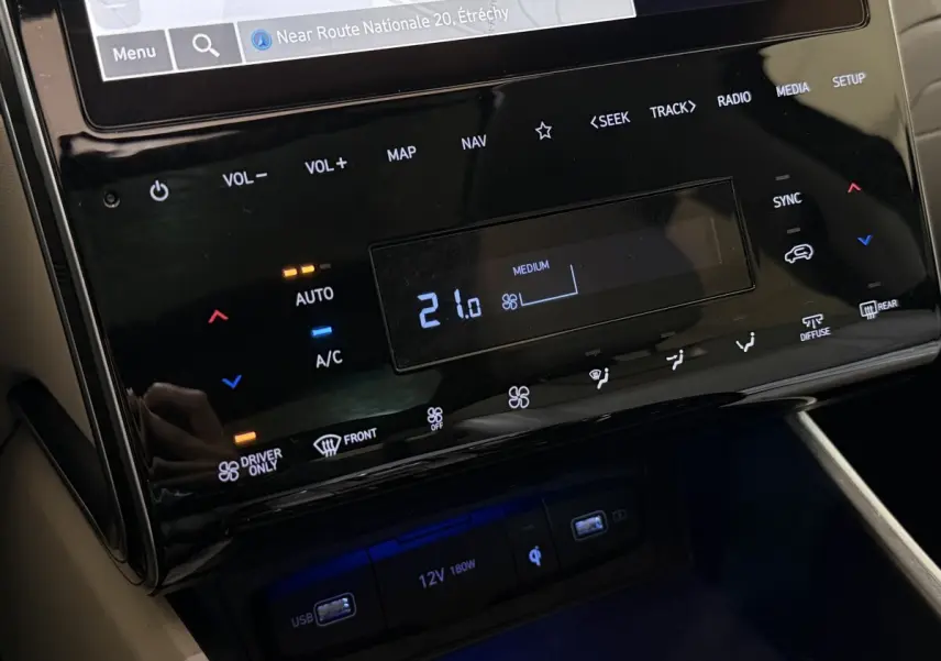Gros plan sur la console centrale tactile noire du Hyundai Tucson 1.6 Hybrid 230 Executive avec commandes climatisation et ports USB.