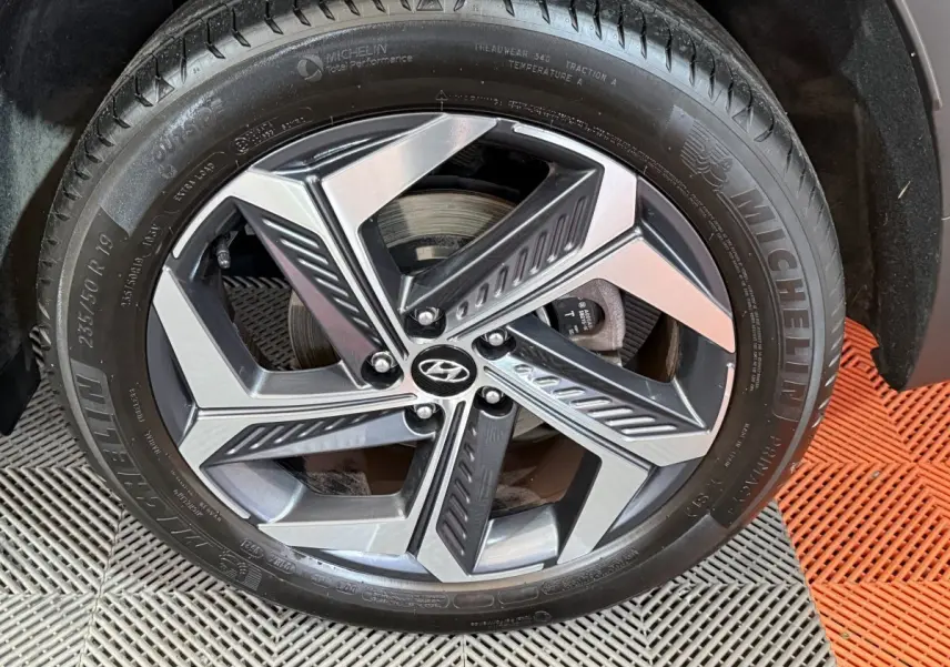 Gros plan sur la jante alliage bicolore et pneu Michelin du côté droit d’un Hyundai Tucson gris foncé.