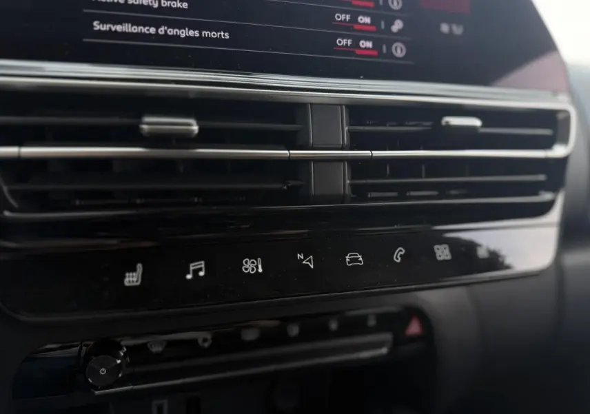 Détail du tableau de bord noir du Citroën C5 Aircross 2025 avec commandes tactiles et aérateurs horizontaux.
