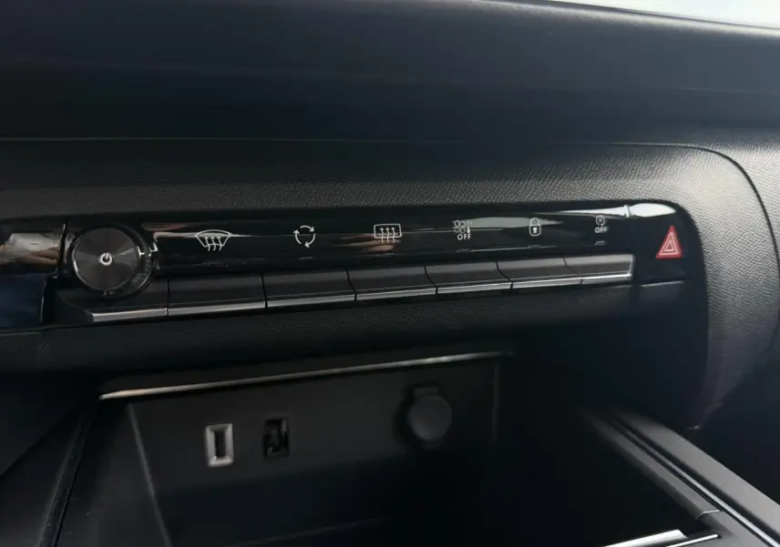 Vue rapprochée de la console centrale noire du Citroën C5 Aircross 2025 avec commandes climatisation et prises USB visibles.