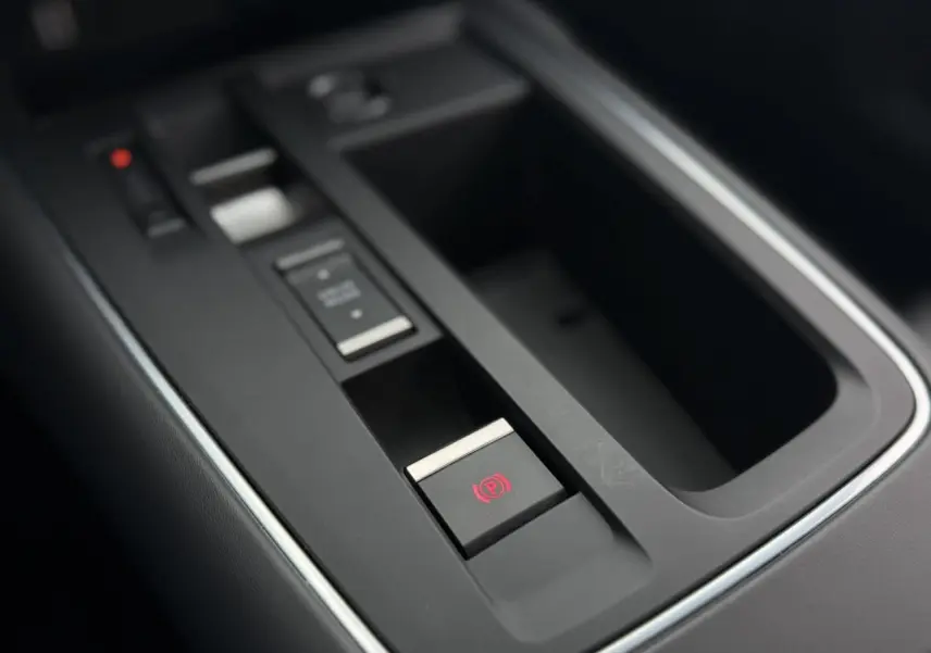 Gros plan sur la console centrale noire du Citroën C5 Aircross 2025, avec frein de stationnement électrique activé.