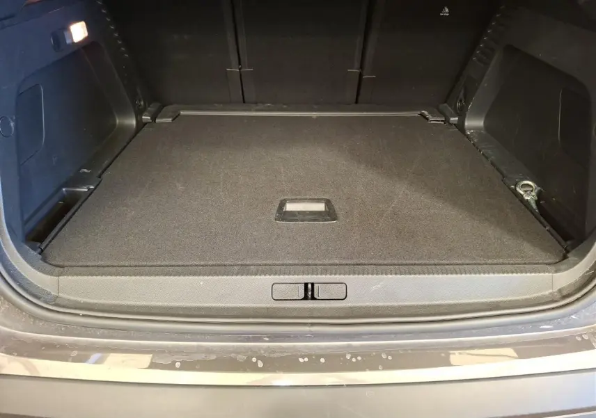 Vue du coffre ouvert du Citroën C5 Aircross gris Platinium, montrant le plancher plat et les rangements latéraux.