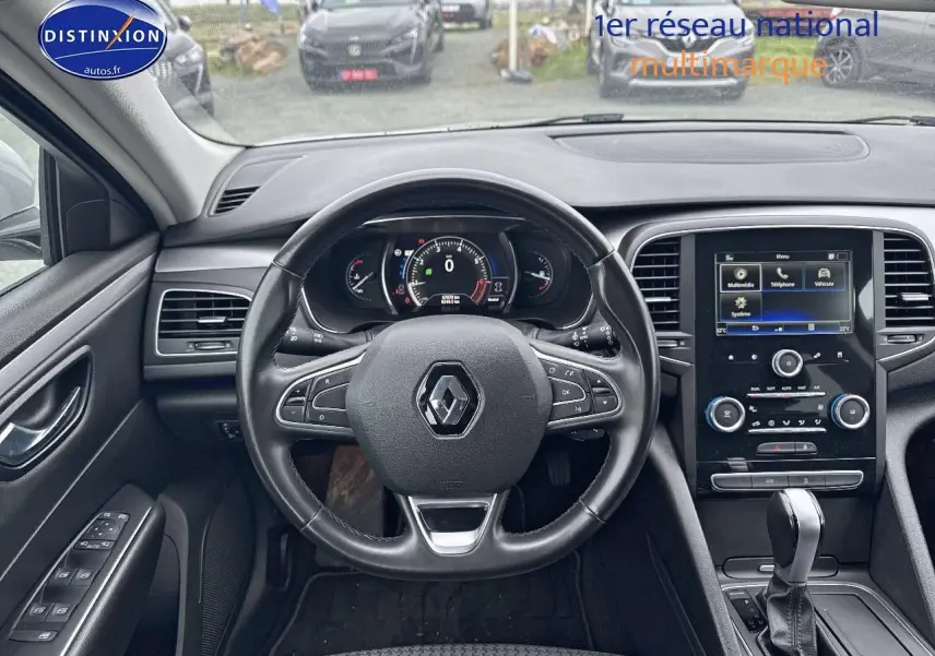 Vue intérieure centrée sur le volant cuir multifonction et l'écran tactile du tableau de bord d'une Renault Talisman 2020.