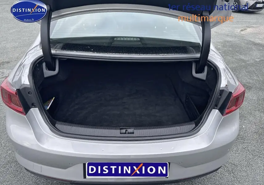 Coffre ouvert vu de l'arrière d'une Renault Talisman gris alu 2020 avec feux arrière rouges et parking en arrière-plan.