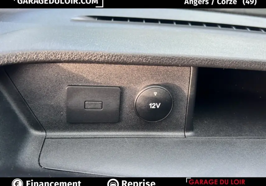 Gros plan sur la prise 12V et un port USB du tableau de bord du Ford Transit Custom Fourgon blanc 2023.