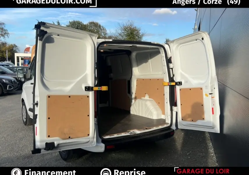 Vue arrière du Ford Transit Custom blanc 2023 avec portes arrière ouvertes montrant l’espace de chargement vide.