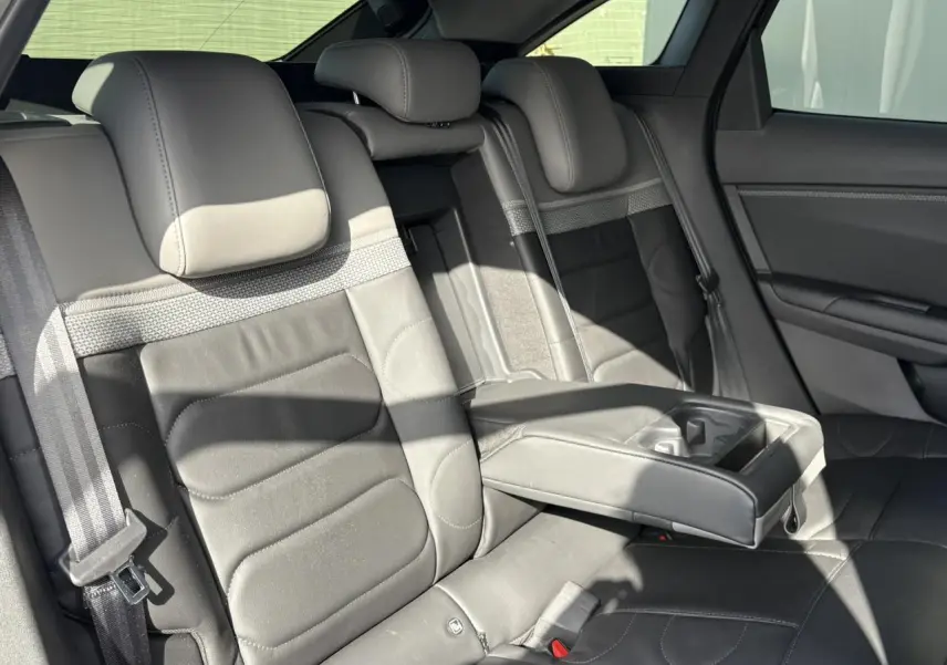 Vue intérieure sur les sièges arrière en cuir gris avec accoudoir central déployé de la Citroën C5 X 2024.