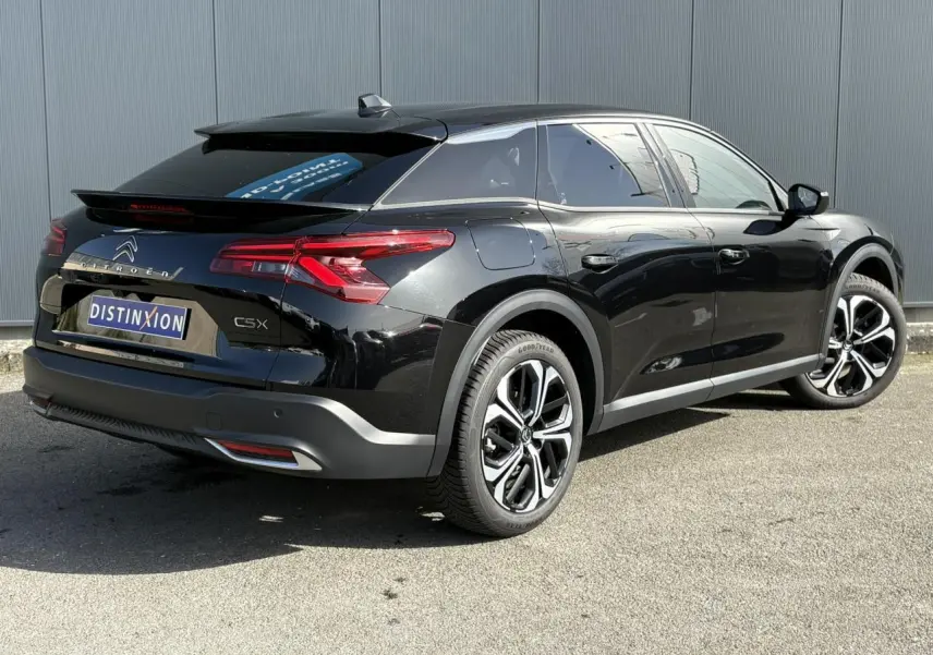 Vue 3/4 arrière droite d'une Citroën C5 X noir Perla avec jantes alliage 19'' et feux arrière LED 3D distinctifs.