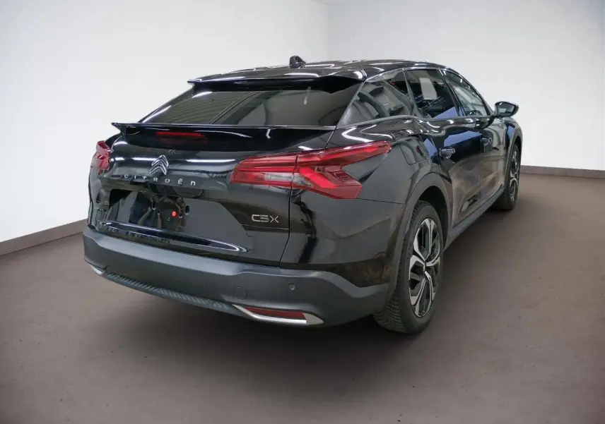 Vue intérieure avant du tableau de bord du Citroën C5 X 2024 avec écran GPS tactile 12 pouces et volant cuir noir.