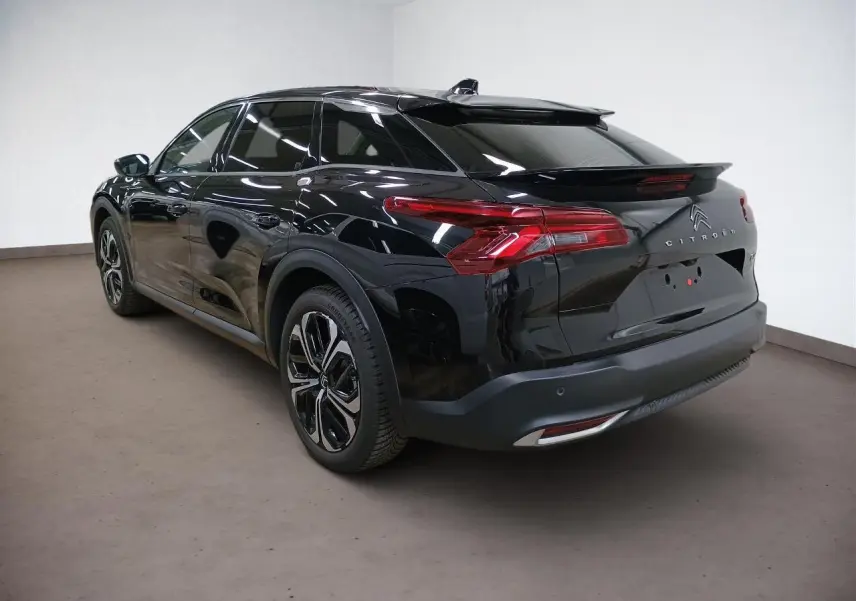 Vue rapprochée du volant cuir noir du Citroën C5 X 2024 avec commandes intégrées et tableau de bord numérique.