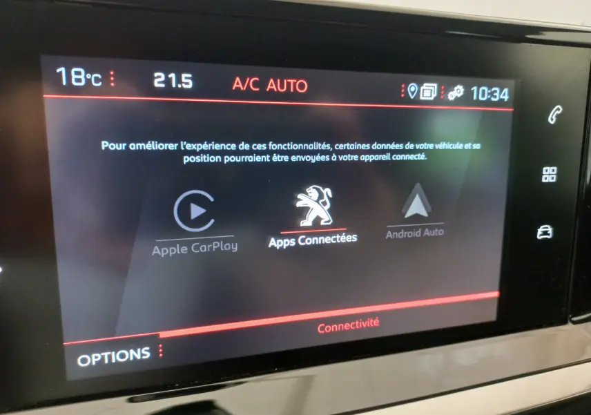 Écran tactile central du tableau de bord du Peugeot 208 blanc, affichant les options Apple CarPlay et Android Auto.