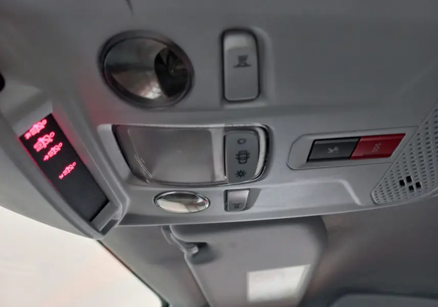 Vue en gros plan du plafonnier gris clair de la Peugeot 208 blanc avec boutons d'éclairage et alarme SOS.