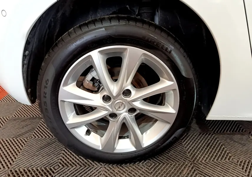 Gros plan sur la roue avant droite avec jante alliage argentée de l'Opel Corsa blanche 2023.