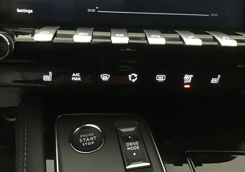 Gros plan sur la console centrale du Peugeot 508 SW 2024, montrant les commandes de climatisation et le bouton start/stop.