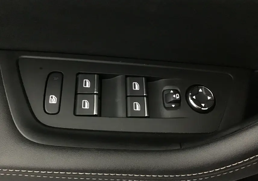 Gros plan sur les commandes de lève-vitres et réglage des rétroviseurs côté conducteur du Peugeot 508 SW gris Artense.