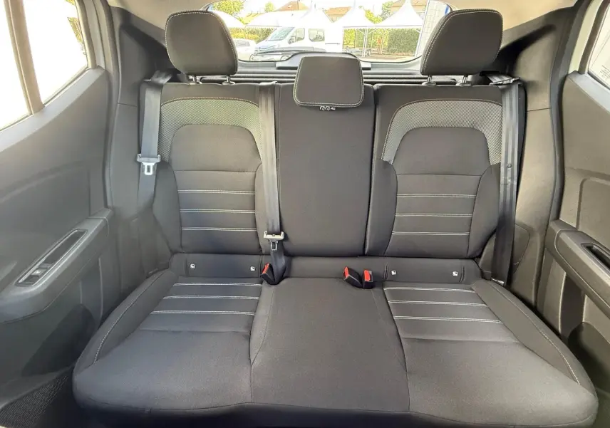Vue arrière des sièges arrière noirs de la Dacia Sandero 2023, montrant les appuie-têtes et ceintures de sécurité.