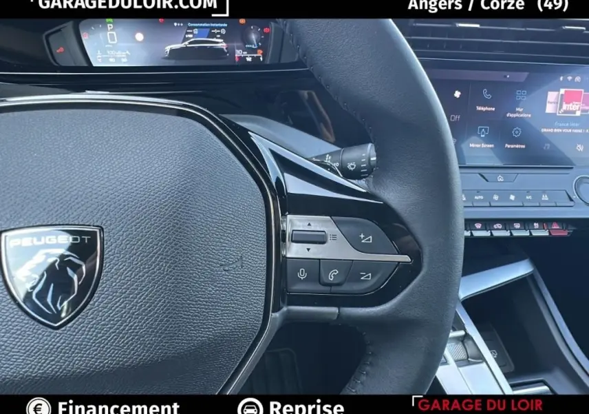 Gros plan sur le volant cuir noir de la Peugeot 308 2023 avec commandes intégrées et tableau de bord numérique.