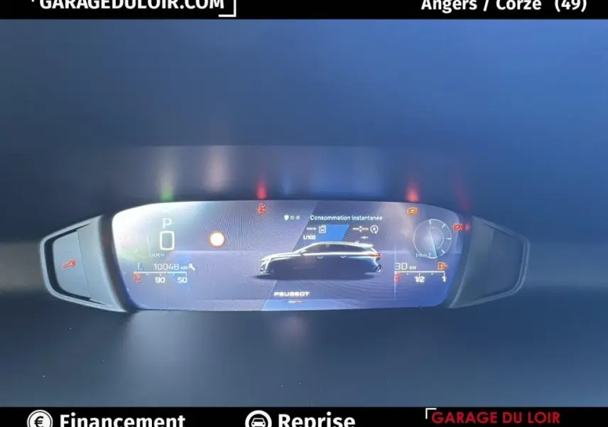 Affichage numérique du tableau de bord de la Peugeot 308 gris clair, montrant la consommation instantanée et les indicateurs.