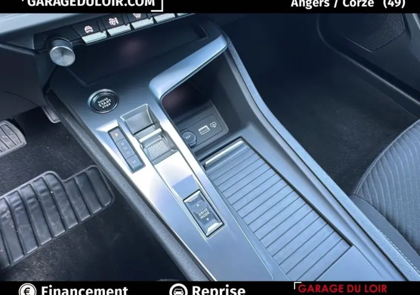 Vue intérieure en plongée sur la console centrale grise de la Peugeot 308 2023 avec bouton start et sélecteur de boîte automatique.