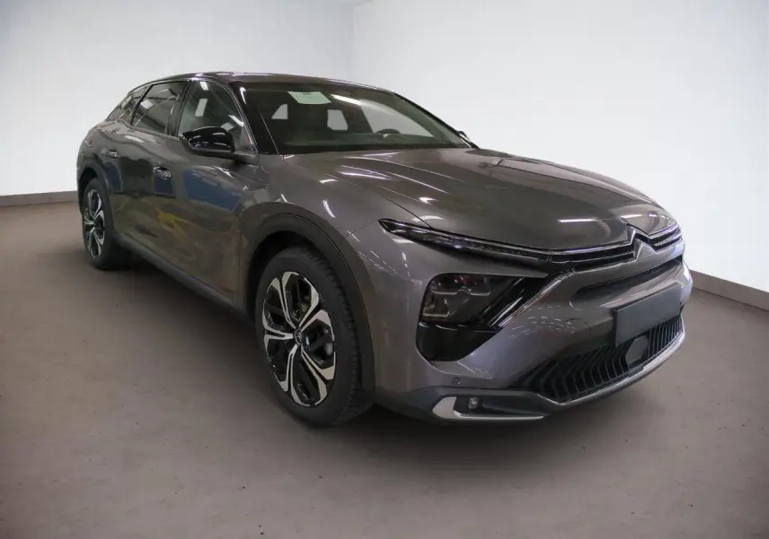 Vue 3/4 avant gauche d'une Citroën C5 X gris Platinium avec jantes alliage noires et signature lumineuse LED en V.