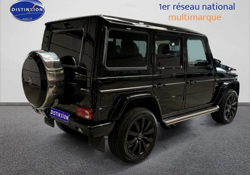 Vue 3/4 arrière droite d'un Mercedes Classe G 5.5 63 AMG noir avec roue de secours chromée et jantes noires.