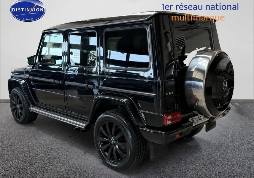 Mercedes Classe G 63 AMG noir vue 3/4 arrière droit avec roue de secours chromée et jantes noires.
