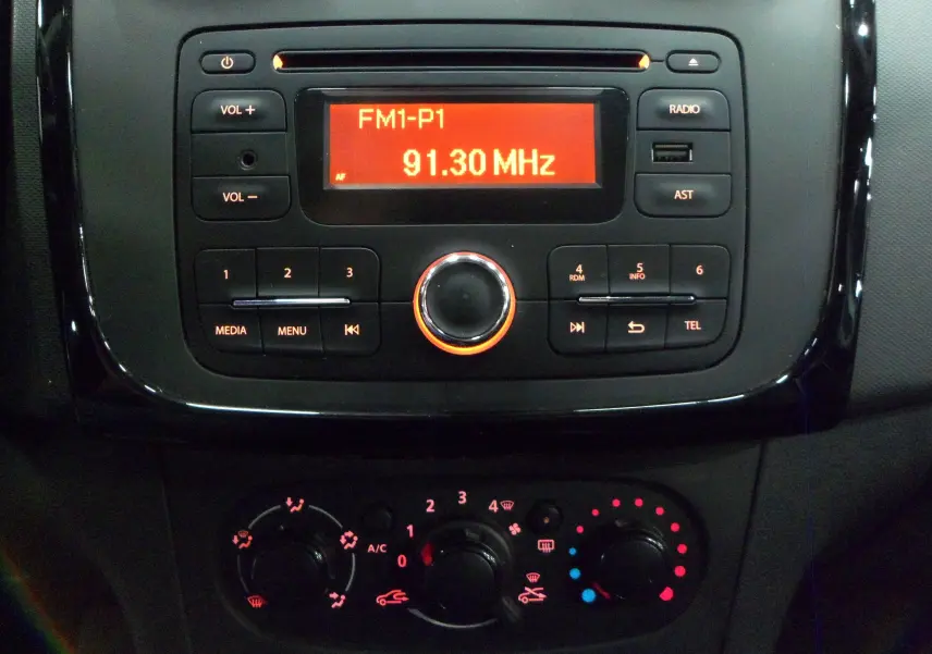 Gros plan sur la console centrale noire de la Dacia Sandero Stepway 2016, avec radio et commandes de climatisation éclairées.
