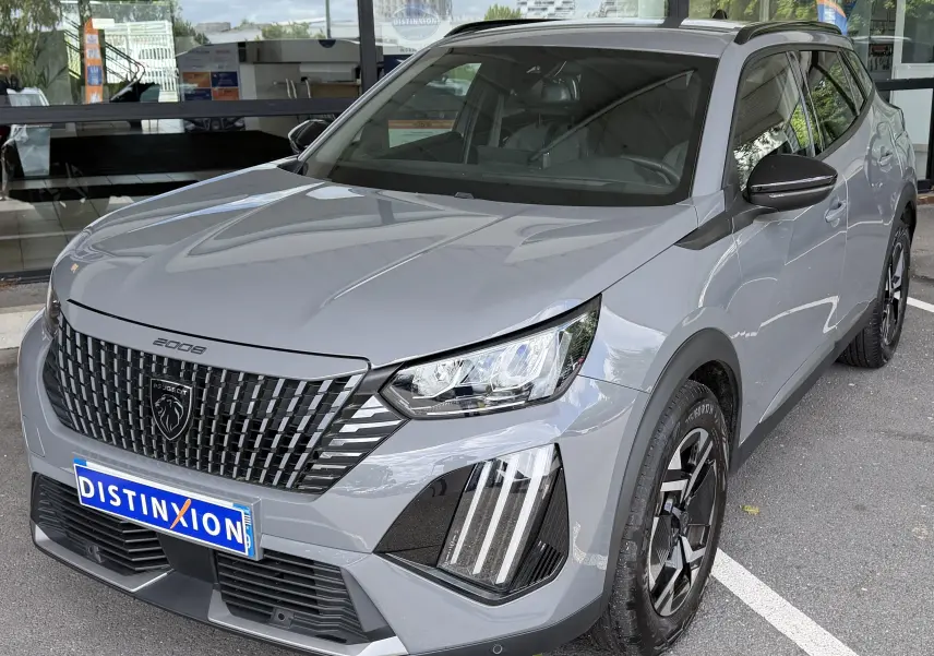 Peugeot 2008 gris Sellenium en 3/4 avant droit, avec calandre noire distinctive et feux LED verticaux.