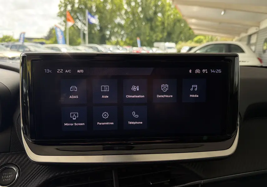Vue intérieure centrée sur l'écran tactile du tableau de bord du Peugeot 2008 gris Sellenium, affichant les options de menu.