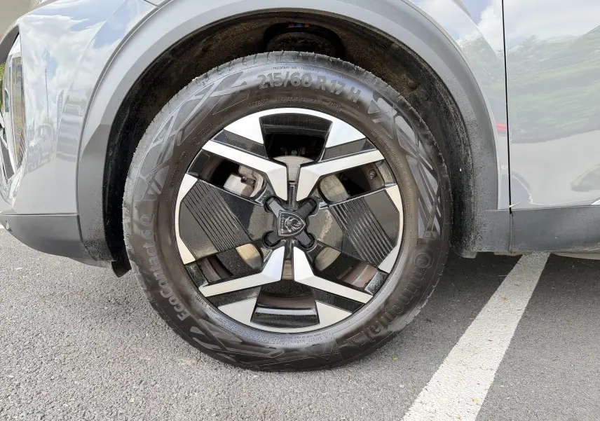 Gros plan sur la roue avant droite du Peugeot 2008 gris Sellenium, mettant en valeur la jante alliage 17 pouces bicolore.