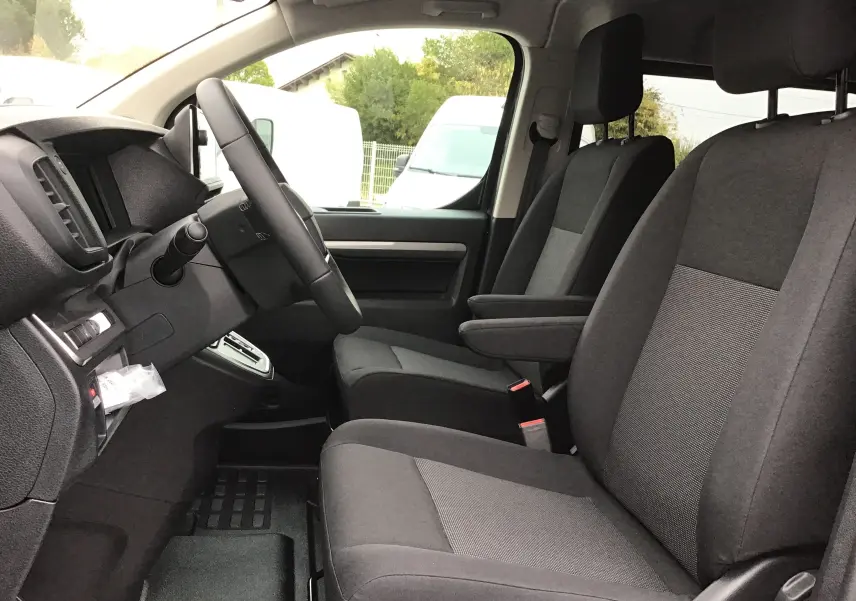 Vue intérieure côté conducteur du Peugeot Expert Cabine Approfondie XL, sièges tissu gris et tableau de bord noir.