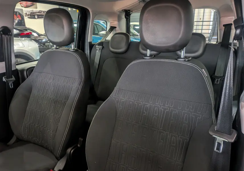 Vue intérieure sur les sièges avant en tissu noir avec motif FIAT embossé de la Fiat Panda 2025 hybride.