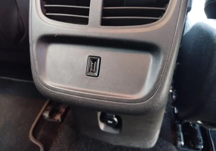 Gros plan sur la prise USB et la sortie d’air arrière dans l’habitacle noir d’un Opel Grandland X 2021.