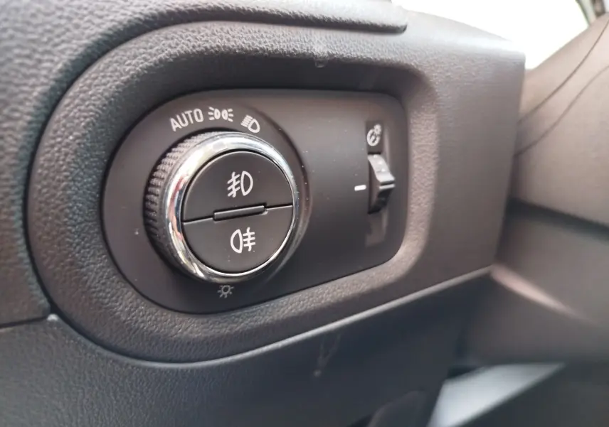 Gros plan sur le bouton de commande des phares et feux antibrouillard dans l'habitacle noir de l'Opel Grandland X 2021.