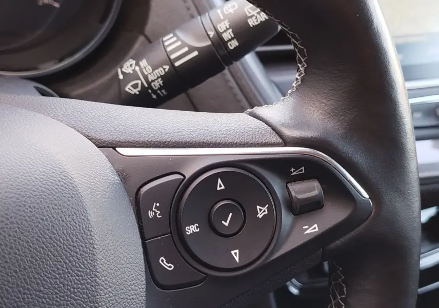 Gros plan sur les commandes multifonctions noires du volant cuir noir de l’Opel Grandland X 2021.