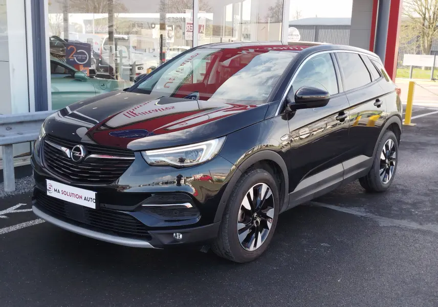 Opel Grandland X noir diamant en 3/4 avant droit, avec jantes bi-ton et calandre noire brillante.
