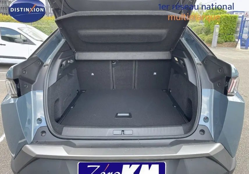 Coffre ouvert du Peugeot 3008 Hybrid 136ch Allure bleu Ingaro métal vu de l'arrière, montrant un espace de chargement spacieux.