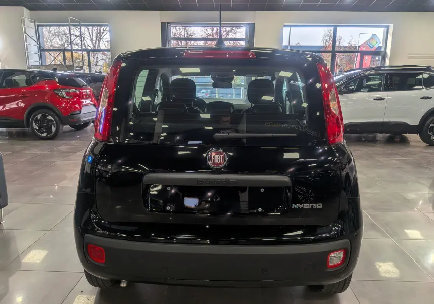 Vue arrière d'une FIAT Panda 1.0 70 CH Hybrid City noire, avec logo FIAT et badge Hybrid visibles dans un showroom.