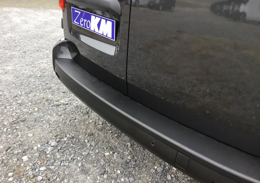 Gros plan sur le pare-chocs arrière gris titane du Peugeot Expert XL avec caméra de recul et capteurs de stationnement.
