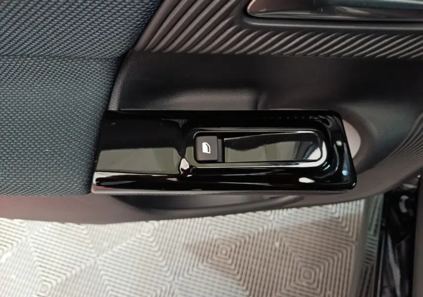 Détail du bouton de verrouillage de porte noir brillant sur la garniture intérieure côté gauche d'une Citroën C5 Hybride bleue.