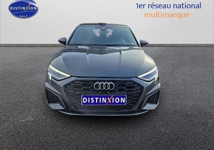 Vue avant d'une Audi A3 Sportback 45 TFSI e 245 S line gris Daytona avec calandre noire et phares LED allumés.