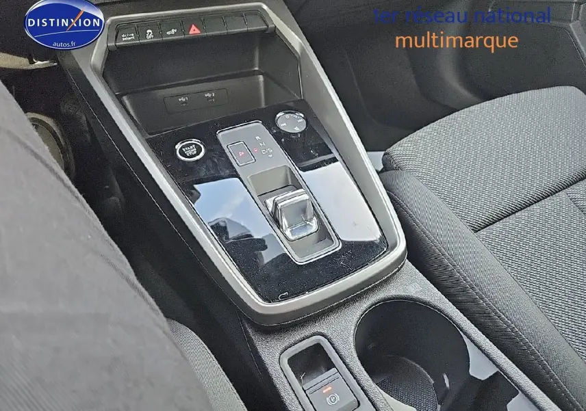 Gros plan sur la console centrale avec levier de boîte auto et accoudoir tissu côté passager de l'Audi A3 Sportback 2024.