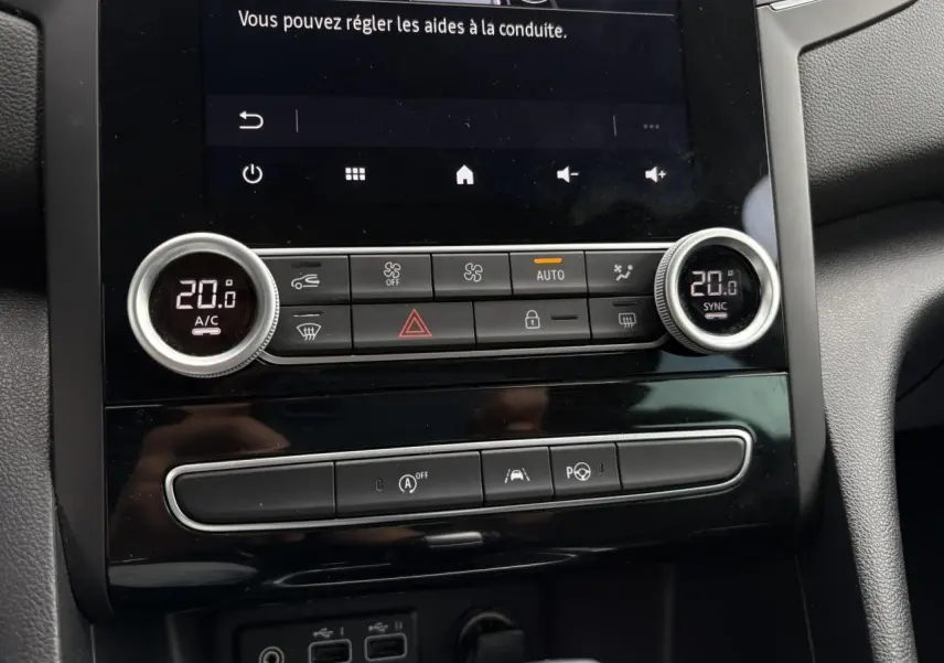 Détail de la console centrale de la Renault Mégane Break 2024 avec climatisation bi-zone et commandes d'aide à la conduite.