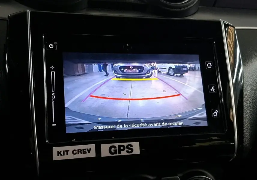 Écran central montrant la caméra de recul d’une Suzuki Swift grise 2023 avec guidage coloré en parking intérieur.