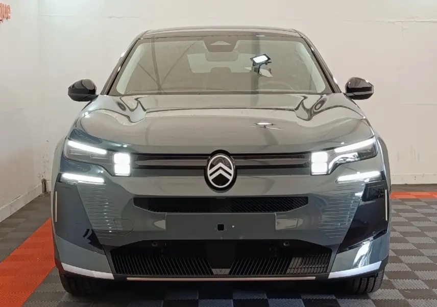 Vue avant frontale d'une Citroën C5 hybride 2026 vert avec phares LED et logo Citroën central lumineux.