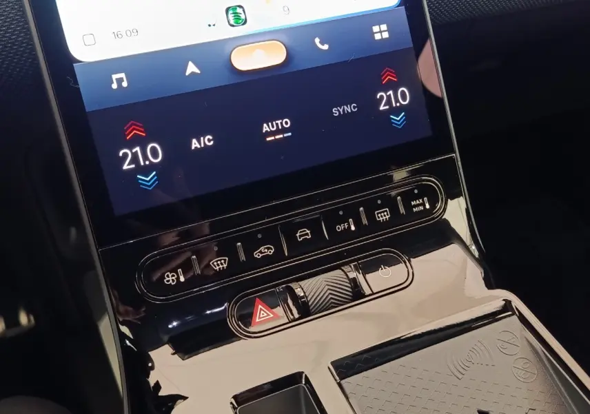Gros plan sur la console centrale tactile de la Citroën C5 Hybride 2026 avec commandes climatisation et recharge sans fil.