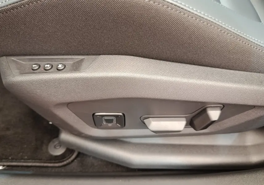 Détail des commandes électriques de réglage du siège avant côté conducteur d'une Citroën C5 hybride verte.