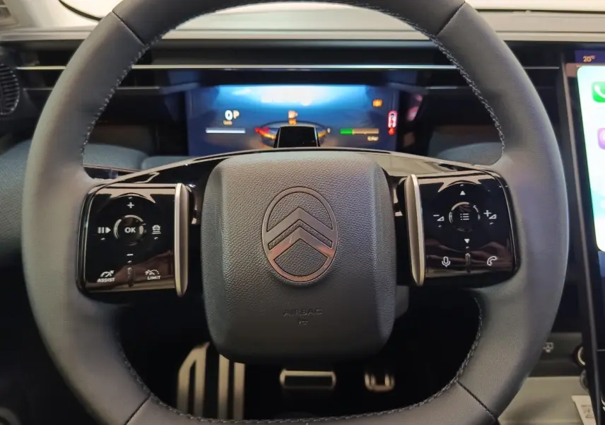 Vue rapprochée du volant cuir noir multifonctions de la Citroën C5 Hybride 2026 avec commandes tactiles intégrées.
